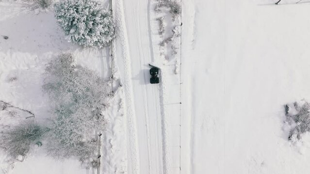 Snow removal truck on the roads in Aspen and Snowmass villages. Aerial drone view on winter snowcat transportation. Roads in winter Colorado. Car for cleaning snow. Snowplows in North America, USA