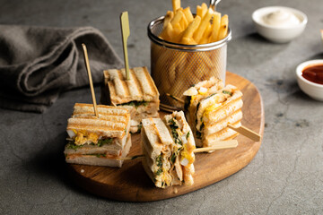 club sandwich and fries with mayo dip and sauce isolated on cutting board side view of fastfood