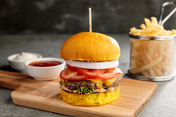 classic chicken burger with ketchup and fries isolated on cutting board side view of fastfood