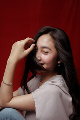Obraz premium Asian woman taking photo on a red background. Happy Asian woman. Beautiful asian woman with long and straight hair.