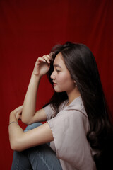Fototapeta premium Asian woman taking photo on a red background. Happy Asian woman. Beautiful asian woman with long and straight hair.