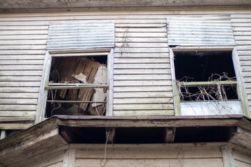 Old wooden weathered dilapidated abandoned two story house looking up at windows