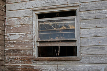 Old wooden weathered dilapidated abandoned two story house open wooden window