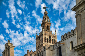 Obraz premium Detailed view of Seville Cathedral’s ornate stone facade with gothic architecture and heraldic shields, Andalusia, Spain. 