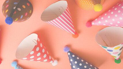 Colorful birthday caps on orange background. Top view.