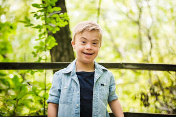 Portrait of a little boy with down syndrome while playing in a park