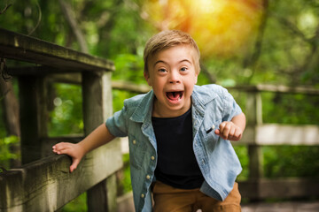 Portrait of a little boy with down syndrome while playing in a park