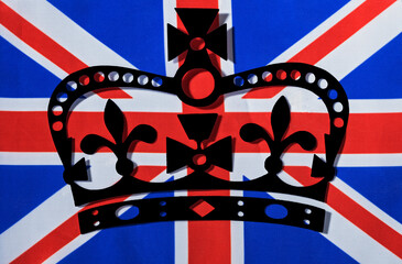 black paper silhouette of the british royal crown on union jack flag