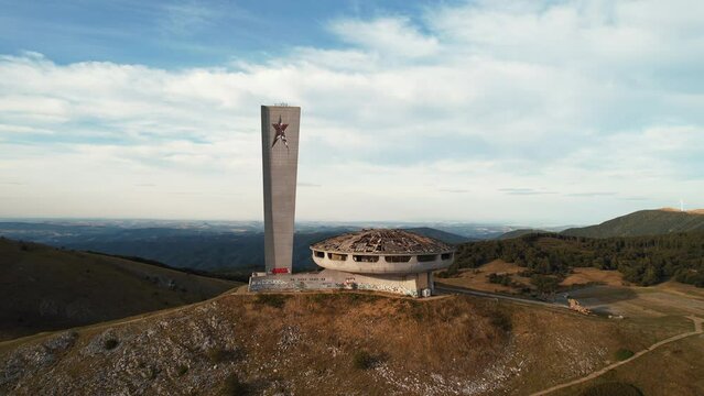 Monument symbol to Communism on top of mountain drone flyby areal view