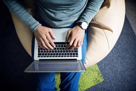 Overhead view of businessman using laptop in creative office