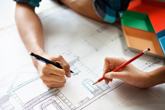 Cropped image of couple examining blueprint at home