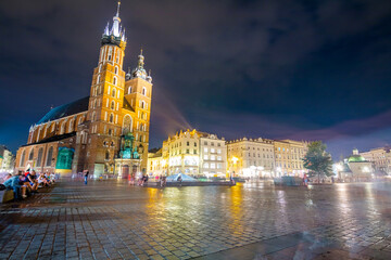 Krakow city in the evening in Poland, Main Square in the Old Town, illuminated St. Mary Church and Cloth Hall (Sukiennice).