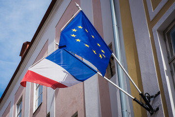 EU and French flags hanging together on a building. European Union and France.