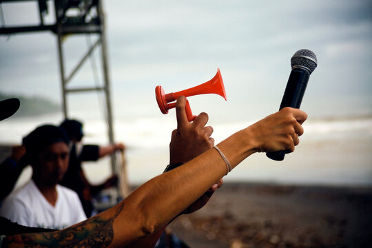 Cropped image of people holding microphone and siren