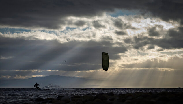 Silhouette person kite boarding in sea
