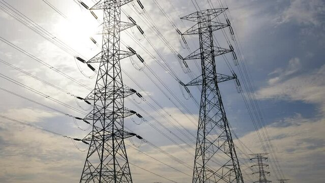 A roll up timelapse footage with noise effect electic transmission tower with moving cloud and sun insight. Electric and energy concept.