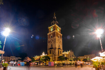 Fototapeta premium Krakow city in the evening in Poland, Main Square in the Old Town, illuminated St. Mary Church and Cloth Hall (Sukiennice).