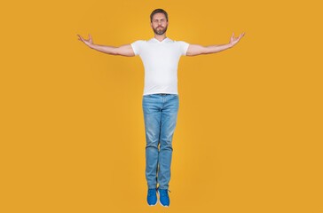 Handsome man levitating yellow background. Grizzled guy levitating midair. Levitating and hovering - obrazy, fototapety, plakaty