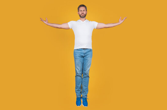 Handsome man levitating yellow background. Grizzled guy levitating midair. Levitating and hovering