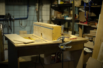 Table in wood workshop. Furniture assembler's workplace. Boards lying on table.