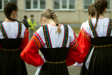 Girl in Russia in folk dress. Preparation for dance. Children perform on street with theatrical...