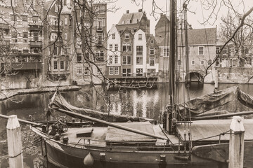 Cityscape, in black-and-white color - view of the canal and moored ship in the old district Delfshaven of Rotterdam, South Holland, The Netherlands
