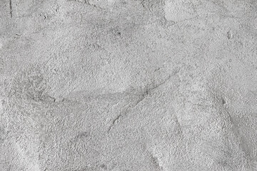 Abstract concrete background - in the form of a rough covered with folds wall, closeup