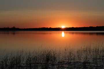 Fototapeta na wymiar Deep golden sunset over northern Minnesota lake in late summer