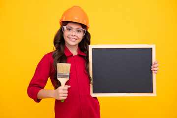 Renovation for childrens room. Little girl in protective helmet and paint brush for painting walls. Happy face, positive and smiling emotions of teenager girl.