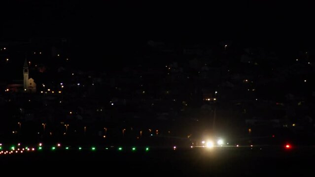 The plane is traveling along the illuminated runway at night. A passenger plane with tourists is taking off. High quality 4k footage