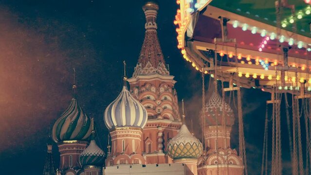 Beautiful, colorful carousel and snow whirl against the backdrop of the St. Basil's Cathedral on Red Square create a festive, New Year's mood