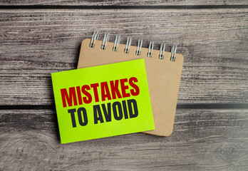 mistakes to avoid text on the green sticker and wooden background