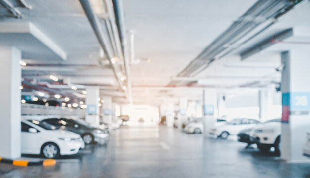 Abstract blur image of Many cars in parking garage interior at department store or shopping mall , industrial building for banner advertising background