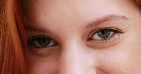 White girl opening eyes, closeup of young redhair woman with green eyes