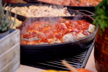 Cooking meat dishes in a summer restaurant on the street. Stuffed cabbage rolls in tomato sauce.