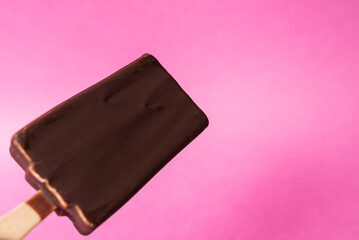 chocolate ice cream on stick on pink background