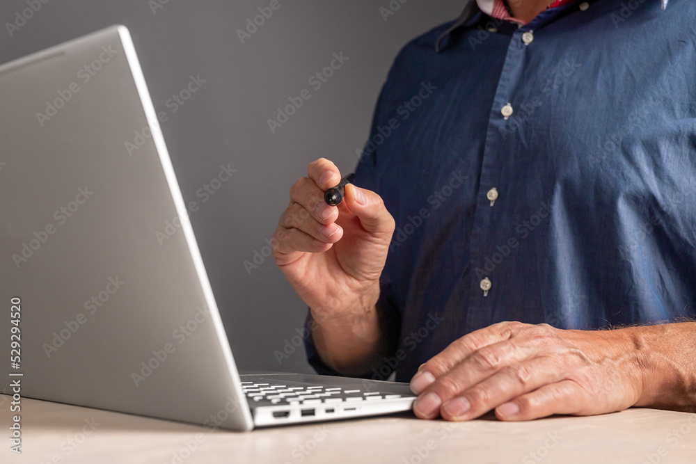 Poster e-signature. man sitting at table with laptop and holding pen for signing electronic document. infor