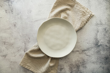 Top view white ceramic plates tableware with natural table napkin linen and light background
