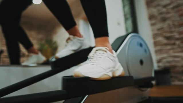Woman training on elliptical trainer in gym