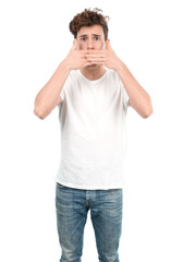 Worried young guy covering his mouth with his hands