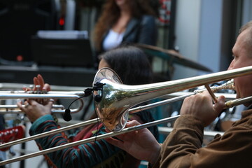 A group of musicians playing wind instruments trumpet and trombone on the street