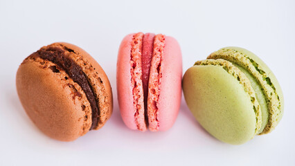 strawberry, chocolate and pistachio macaroon against white background