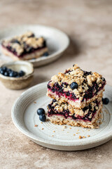 Vegan baked oatmeal squares with fresh blueberry on beige background