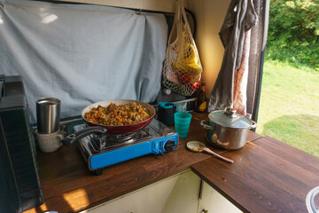 Typical Vanlife situation during cooking dinner with pan on a gas stove