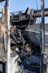 Fototapeta na wymiar Burned out RV motorhome interior from a fire or explosion or fire bomb or arson shows the melted interior and the devastation of the accident.