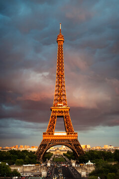 Low angle view of Eiffel Tower against cloudy sky during sunset