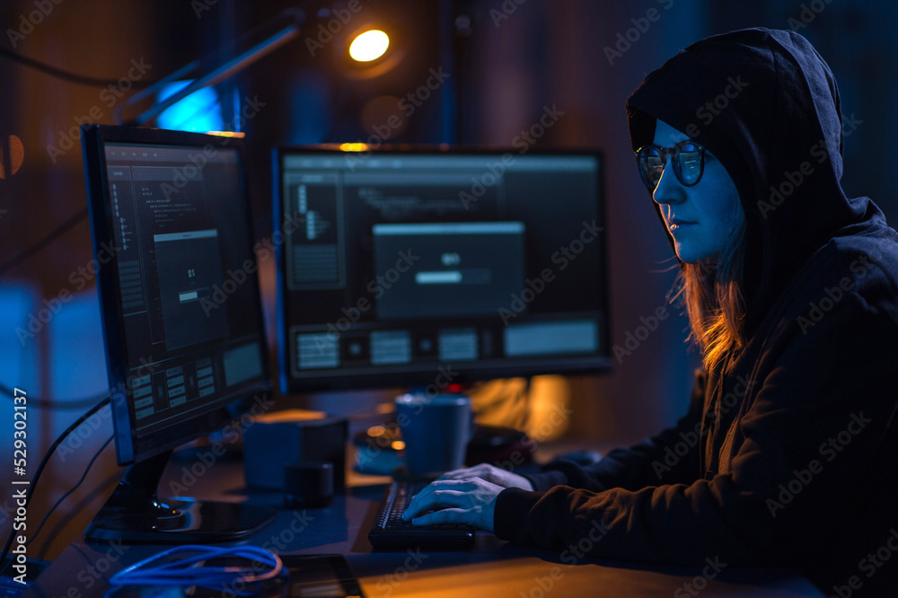 Poster cybercrime, hacking and technology concept - female hacker in dark room writing code or using comput