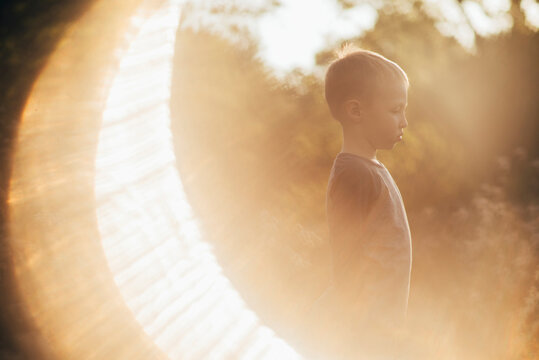 Side View Of Boy In Forest On Sunny Day