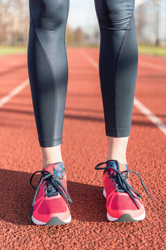 Low section of female athlete standing on sports track