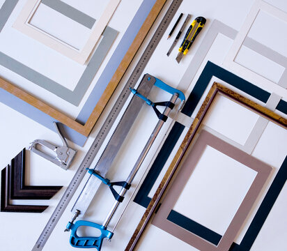 Overhead view of picture frames with work tools on table in workshop
